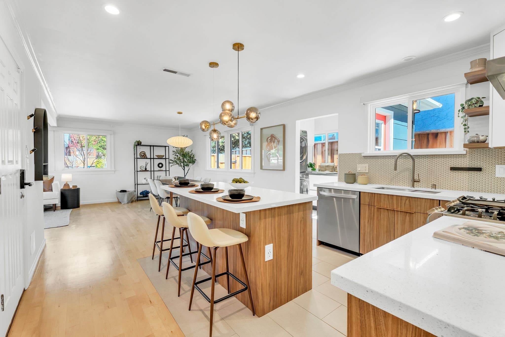 Open-plan kitchen with a walnut island and brass pendants